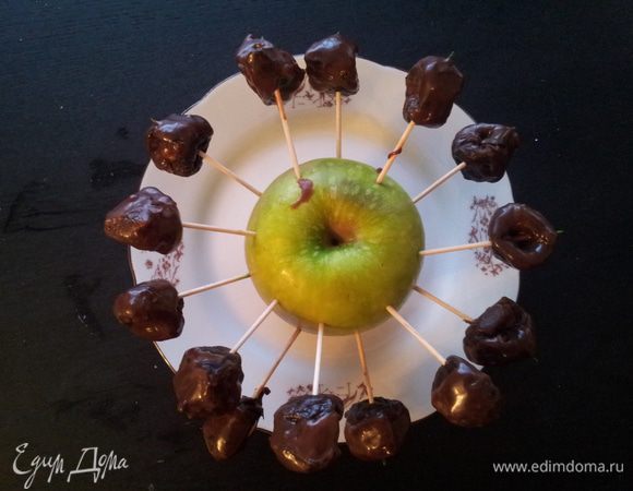 Чернослив помыть, распарить и вынуть косточки. В отверстие от косточки положить орешек. Шоколад растопить. Обмакнуть каждую черносливу в шоколад и при помощи зубочистки прикрепить к яблоку. (а если прикрепить к апельсину получится солнышко). Поставить чернослив в холодильник до застывания. Всем приятного наслаждения. 