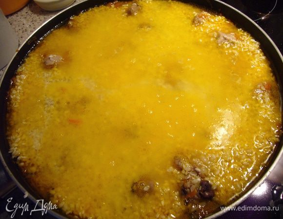 Теперь берём блюдце, переворачиваем его вверх дном и над сковородой начинаем лить на блюдце воду, равномерно распределяя её по всей поверхности сковороды. Вода должна быть почти кипящей, так что осторожно с пальцами! Для чего это делается? Если вы просто выливаете воду из чайника или из кружки, то она сделает ямку в вашем утрамбованном слое риса, а рис нам тревожить не надо. Воды нужно налить так, чтобы она покрывала поверхность риса и превышала её на пару пальцев. Подсаливаем воду немного.
Накрываем сковороду (казан) крышкой, дожидаемся начала закипания на среднем огне, уменьшаем огонь до минимального и томим плов, пока вода не выкипит. У меня уходит примерно 20-30 мин. 