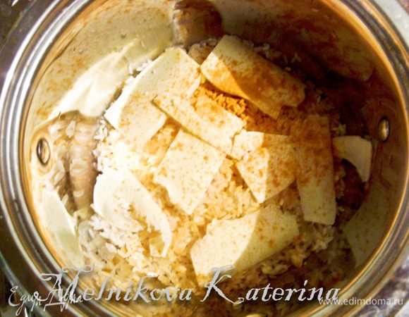 Рис промойте. Выложите в кастрюлю слоями примерно по 1 см толщиной, перекладывая тонкими ломтиками сливочного масла, пересыпая солью и куркумой. Залейте рис водой в соотношении 1 к 2 и варите до готовности.