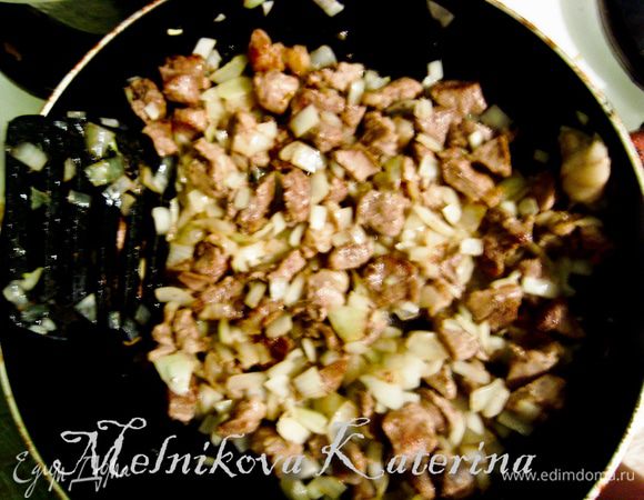 Нарежьте небольшими кубиками лук и добавьте к мясу. Жарьте 5–7 минут.