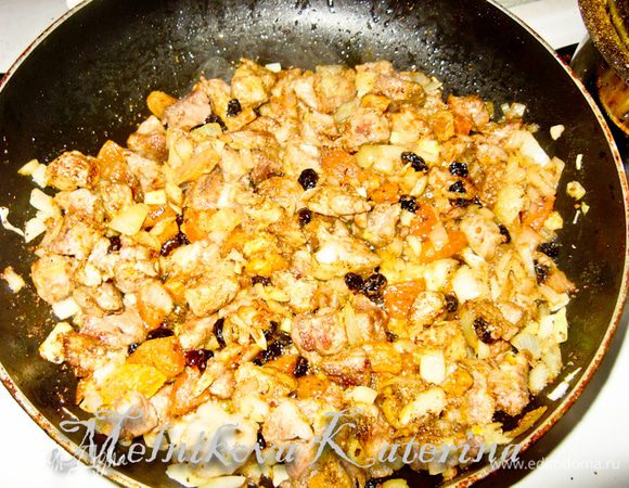Добавьте изюм и курагу к мясу, тушите 2–3 минуты. Добавьте специи, перемешайте.