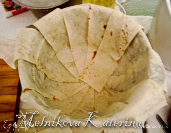 Растопите сливочное масло. Смазазывая каждую полоску с одной стороны сливочным маслом, выложите в казан веером. Необходимо оставить свисающие части лаваша.