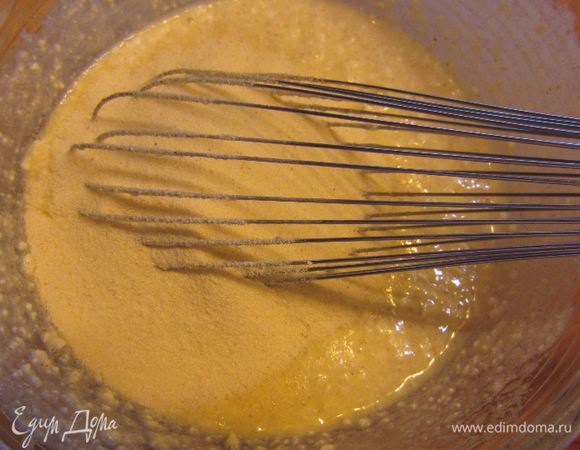 Добавьте в смесь манку. Добавьте сметану. Тоже хорошо размешайте.