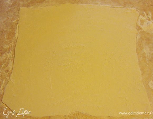 Раскатайте тесто до размеров 50 на 50 сантиметров. Оно должно получиться довольно тонким - как для пельменей.