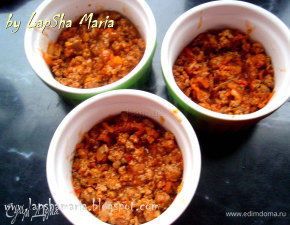 Есть несколько вариантов подачи. Можно  запечь пирог в одной большое форме, а можно порционно. Я выбрала второй способ. На дно кокотницы выкладываем слой мяса. Его должно быть достаточно много, примерно половина кокотницы, может чуть меньше.