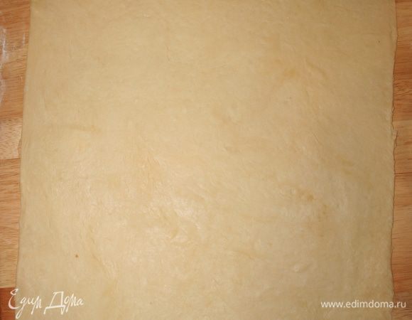 Присыпаем поверхность мукой, раскатываем тесто в прямоугольник около 35-40 см в длину толщиной 0,5 см. 