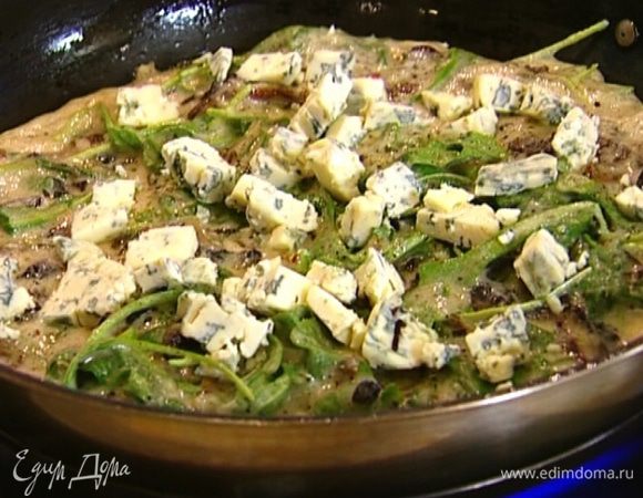 Дать омлету схватиться по краям, затем разложить сверху голубой сыр.