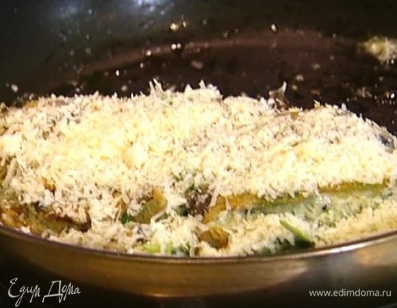 Когда низ омлета прожарится, поддеть одну часть и накрыть ею вторую, посыпать оставшимся пармезаном и отправить на 1–2 минуты под гриль. 