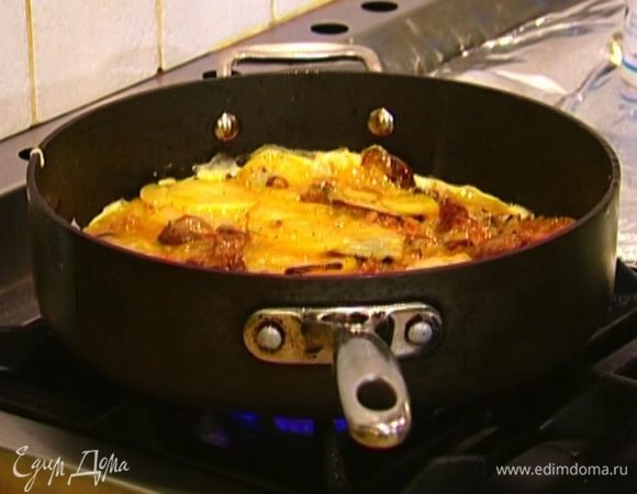 Добавить жареный картофель, все перемешать и выложить обратно на сковороду, равномерно распределить и на медленном огне дать омлету пропечься.