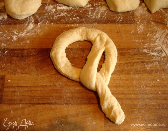 Левый конец колбаски загнуть на право и вверх,придавить пальцем к петле.Повторить ту же операцию с правым концом колбаски.Немецкие пекари делают это виртуозно быстро.