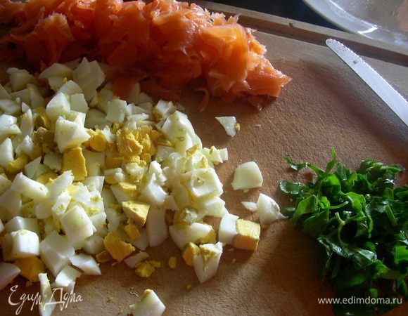 Яйца отвариваем и мелко рубим, режем мелко лосось и зелень.
