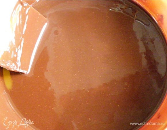 Как только вода закипит, кастрюльку лучше отставить и, не снимая миску с шоколадом с нее, помешивая, растопить и шоколад, и масло. Снимем миску с водяной бани и немного остудим содержимое 