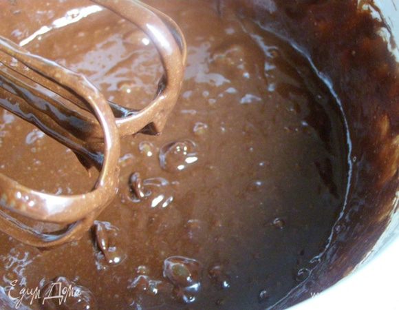 Переключим скорость миксера на среднюю и тонкой струйкой, не прекращая взбивание, вольем шоколадно-масляную смесь