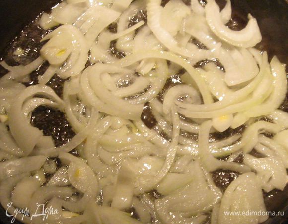 В сковороду, в которой будет тушиться курица, налейте оливковое масло и положите зубчик чеснока и луковицу, нарезанную тонкими полукольцами. Слегка обжарьте до появления легкого запаха лука.