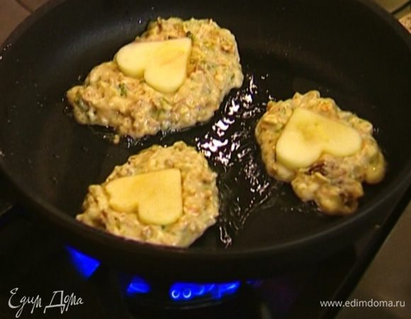 Разогреть в сковороде оливковое масло, ложкой выкладывать в нее тесто в виде лепешек, на каждую лепешку положить по яблочной фигурке и чуть-чуть ее вдавить. Обжаривать оладьи по 3–4 минуты с каждой стороны.