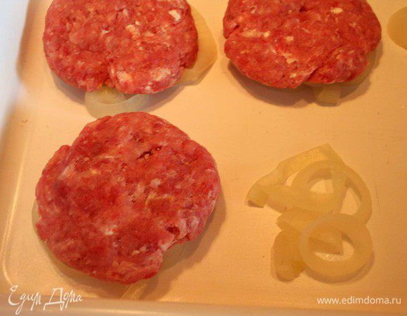 Лук укладываем на противень или жаропрочную кастрюлю. Из фарша формируем круглые плоские котлетки и выкладываем на лук. Отправляем в духовку, разогретую до 180 градусов.
Запекаем 20 минут периодически переворачивая.