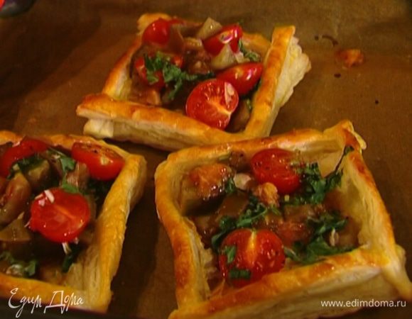 На сыр выложить измельченные помидоры с чесноком и базиликом и помидоры черри. Сбрызнуть пирожки оливковым маслом и запекать еще 2–3 минуты.