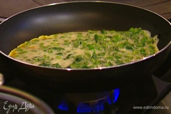 Разогреть в сковороде оливковое масло, выложить яичную массу и равномерно распределить ее, а затем посыпать сыром.