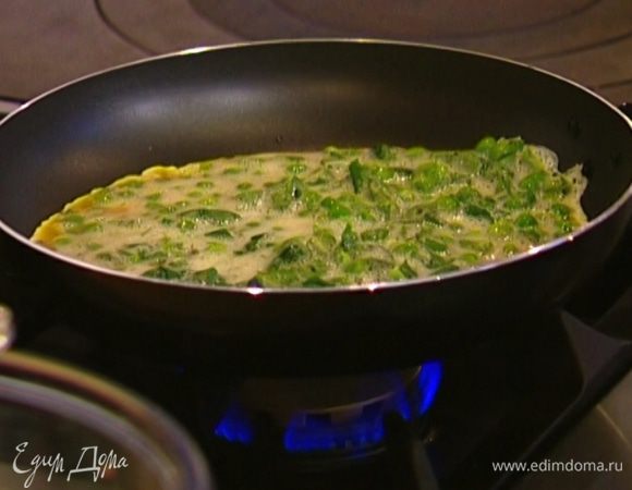 Разогреть в сковороде оливковое масло, выложить яичную массу и равномерно распределить ее, а затем посыпать сыром.