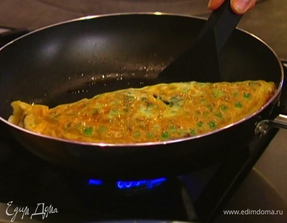 Когда края омлета схватятся, свернуть его пополам и выложить на тарелку.