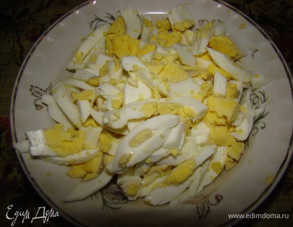 Далее соломкой нарезаем отваренные яйца