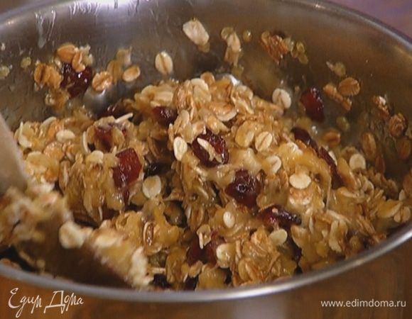 Порциями всыпать овсяные хлопья, каждый раз вымешивая, чтобы хлопья равномерно пропитались маслом.