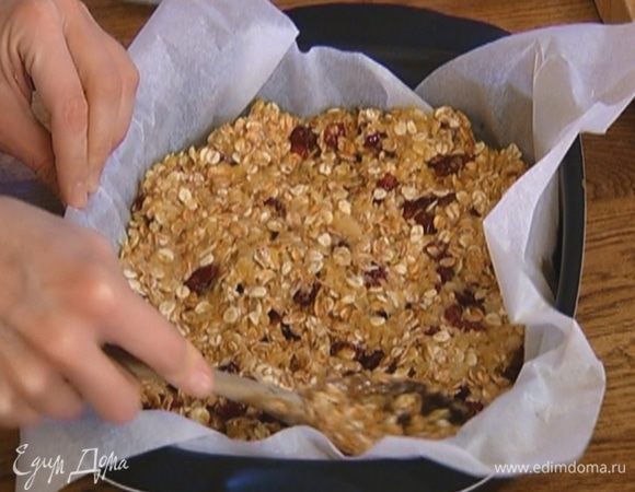 Форму выстелить бумагой для выпечки, выложить овсяное тесто, разровнять и отправить в разогретую духовку на 15 минут.