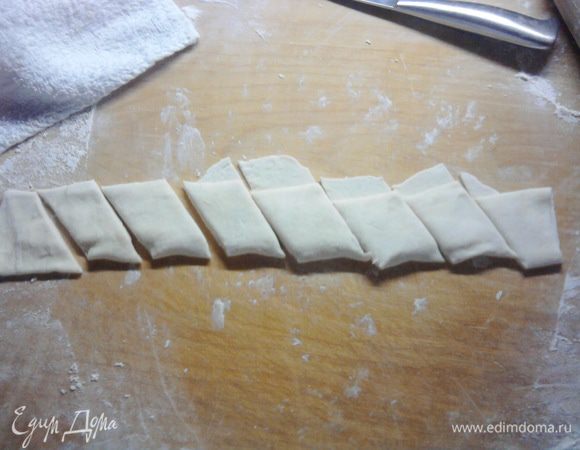 Раскатанный кусочек посыпаем мукой с двух сторон, это необходимо чтобы в дальнейшем рулетик не слипался, а при разворачивание в сковородке это тоже очень поможет. Сворачиваем тесто в рулетик, но при этом не очень плотно. Разрезаем под углом в 45 градусов. Чтобы потом рулетики не разворачивались. я аккуратненько прищипывала к основанию края.