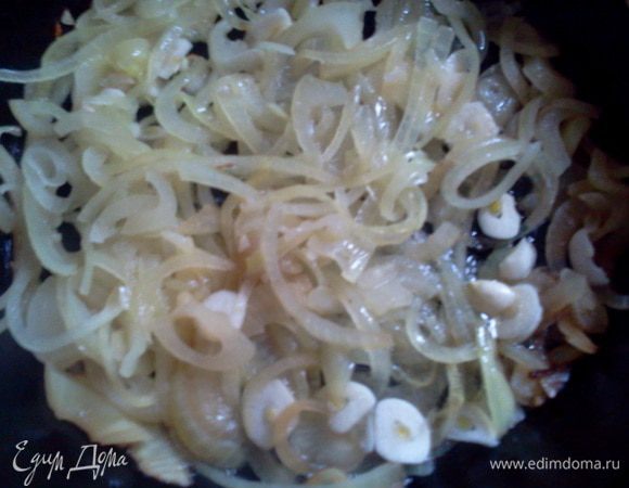 На масле обжариваем лук колечками, добавляем немного чеснока.