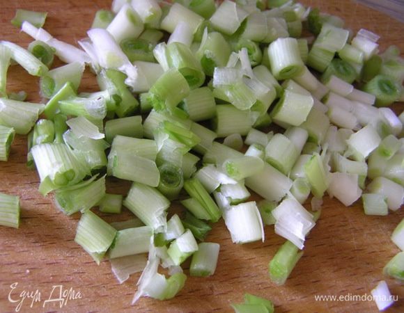 А пока приготовить начинку. В небольшой сковороде на растительном масле обжарить нарезанную нижнюю "белую" часть перьев лука, 