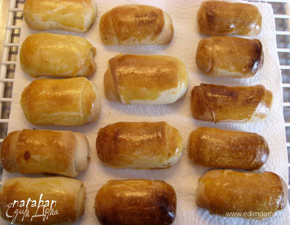 Достать противень с готовыми ореховыми рулетиками и переложить их остужаться на решётку, застеленную кухонным бумажным полотенцем. Прикрыть рулетики льняной салфеткой на 20-25 минут.