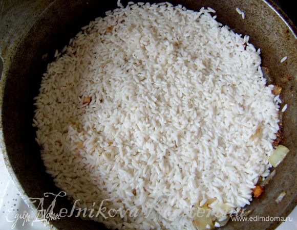 Слить с риса воду, выложить рис поверх зирвака, налить воды (кол-во воды = кол-ву риса) и готовить на медленном огне до готовности, пока вода не испарится и верхний слой риса не будет готов. 