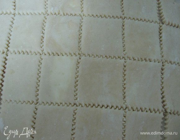 Достать из холодильника, разделить пополам,часть теста раскатать в пласт3-5 мм, фигурным ножом разрезать тесто на квадраты/ромбики/прямоугольники. 