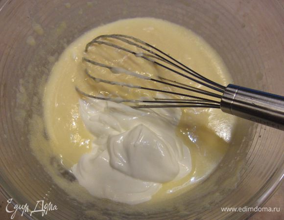 Положите в получающееся тесто сметану и хорошенько взбейте. Не волнуйтесь, если вам покажется, что тесто свернулось. После добавления муки текстура восстановится.