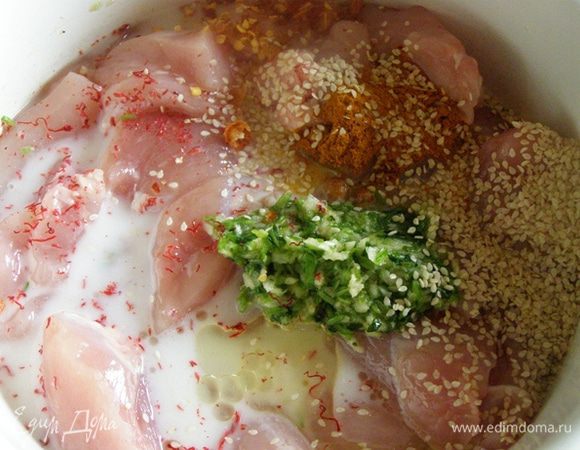 Кунжут слегка обжарим на сухой сковороде. К куриному филе выложим растертый с кинзой чеснок, добавим лепестки шафрана, карри, кунжут, раздавленный острый перец, кунжутное масло, рыбный соус, растительное масло и напиток "Тан". 