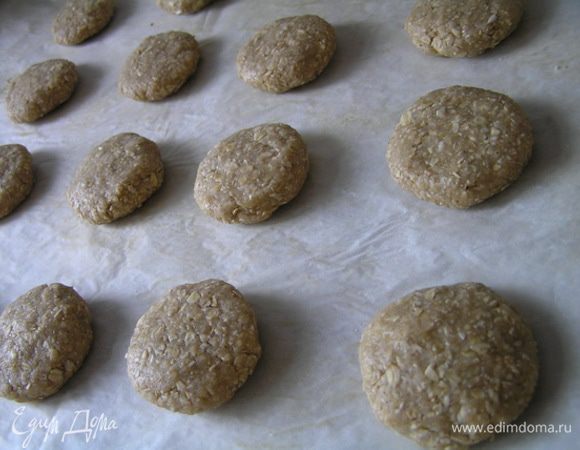 Из получившейся массы сформировать шарики размером чуть больше грецкого ореха, затем их приплюснуть и выложить на противень для выпечки, застеленный кулинарной бумагой.