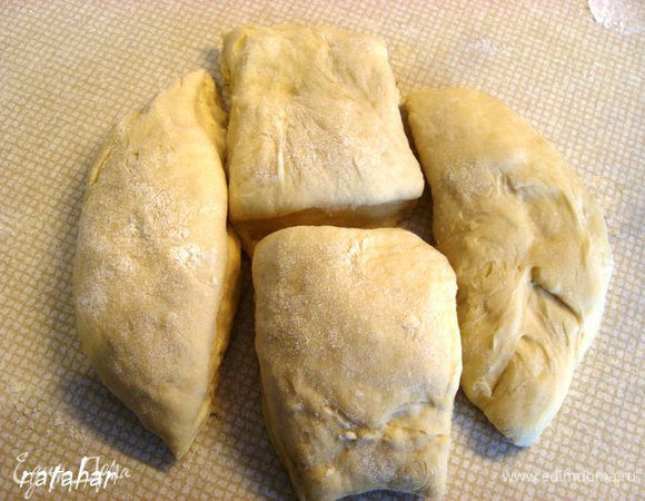 Из одной части теста руками сформировать лепёшку диаметром примерно 20 см, которую разрезать на 4 части...