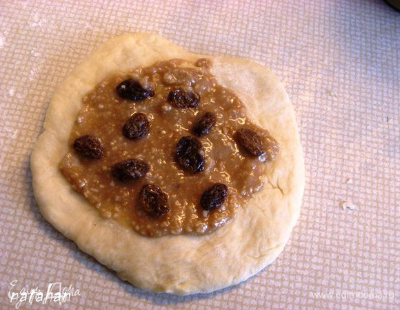 Из шарика руками (скалкой не работаем с дрожжевым тестом по совету Надежды) сформировать лепёшку диаметром примерно 20 см. В середину лепёшки положить 1.5 ч.л. марципано-ореховой массы, которую равномерно размазать по поверхности лепёшки не доходя до края 1.5 см, сверху выложить 1/6 (у меня будет всего 6 булочек) часть изюма.