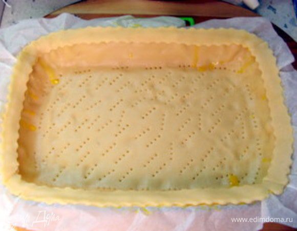 Смазать яйцом край теста в форме и наложить сверху полоски, слегка прижав. Снова смазать полоски сверху яйцом. Наколоть вилкой тесто.