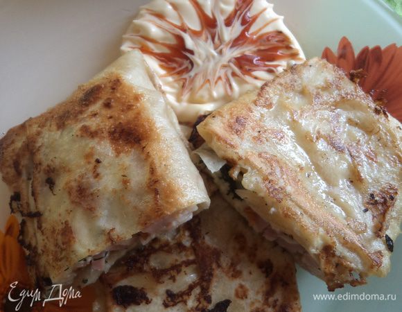 На каждый кусочек лаваша выкладываем сыр и ветчину, делаем конвертик. Затем обмакиваем все это в яичной смеси и жарим до готовности на масле, подрумяниваем с обеих сторон. 