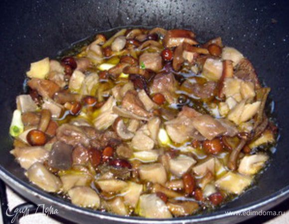 Приготовить начинку. Обжарить грибы на оливковом масле с зубчиком чеснока и листиком шалфея. Посолить, поперчить в конце.