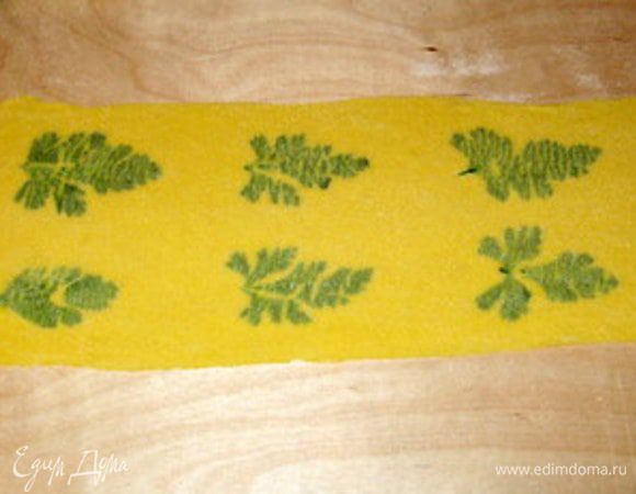 Накрыть другой сфольей. Раскатать две сфольи с листиками посередине в тонкую сфолью. Она должна быть настолько тонка, чтобы листики просвечивали.