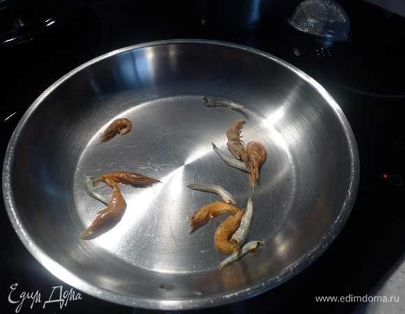В течение 30 секунд обжариваем на сухой сковороде креветки и анчоусы.  