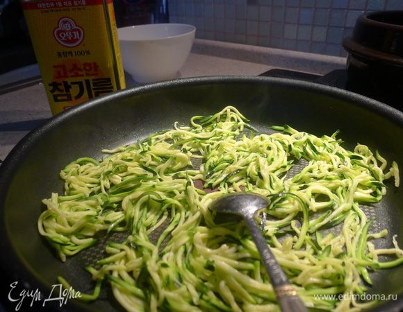 Отжать кабачок и морковку. На смазанной растительным маслом сковородке обжарить в течение 30 сек. сначала кабачок.