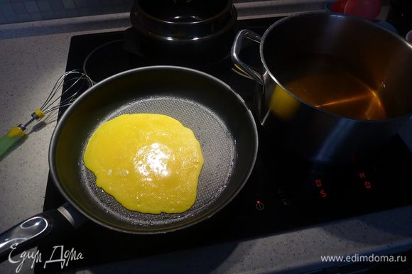 На смазанной растительным маслом сковороде на медленном огне "печем" блинчик из желтков. Рядом в кастрюле бульон для куксу.