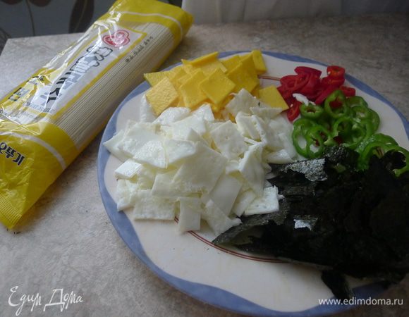 Режем ромбиками остывшие желток и белок. Руками рвем на кусочки лист нори.