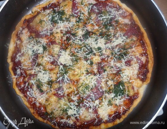Готовую пиццу посыпаем зеленью и тертым сыром.