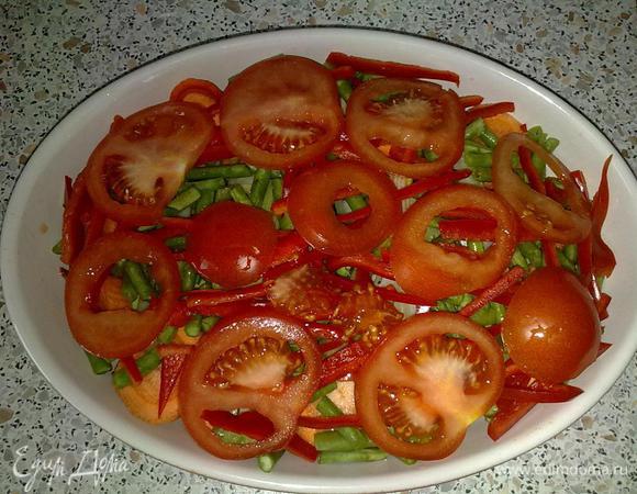 Помидор порезать кружками и выложить поверх фасоли и сельдерея. Немного посолить и сбрызнуть оливковым маслом.