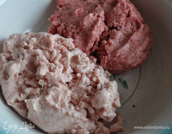 Говяжий и куриный фарш выложите в большую емкость.
