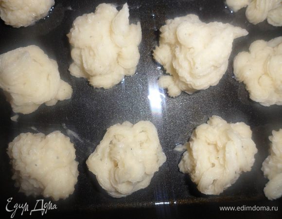 Выложить картофельное пюре в кондитерский шприц и отсадить его на смазанный маслом противень. Смазать смесью из яйца и сливок.